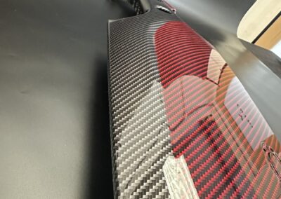 Red and black carbon weave catching the light on a dash trim