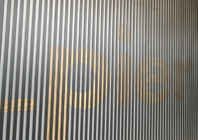 Lit wood grain Pier lettering on a slatted wall at Fulham Pier