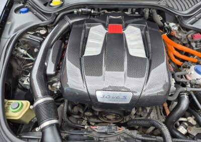 Porsche engine bay with carbon fibre cover and intake pipe