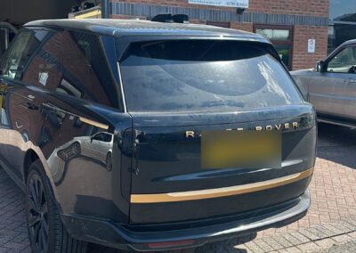 Gold painted tailgate trim and lettering on a black Range Rover