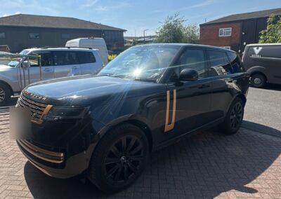 Black Range Rover with gold painted trims, front three-quarter view